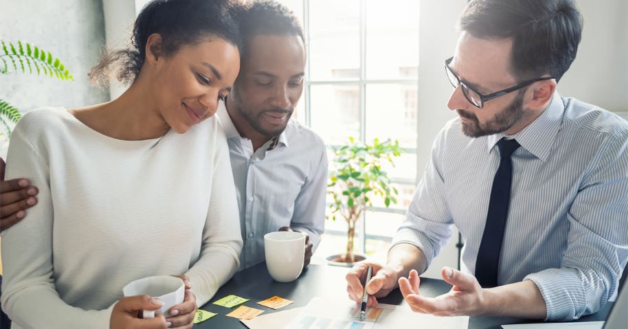 Agente de seguros de auto ayudando a una pareja a elegir su cobertura.