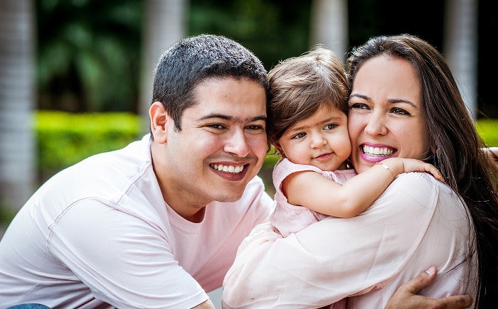 Hispanic family of three smailing