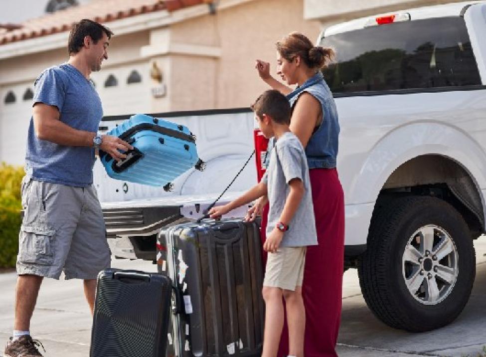 Family loads up their truck while parked in the driveway of their house.