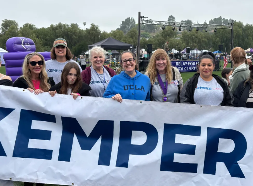 Kemper Cares volunteers hold a Kemper banner while participating in an outdoor event